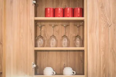 a cabinet with red cups and wine glasses in it at Stylish 1BR apartment in the heart of Koukaki in Athens