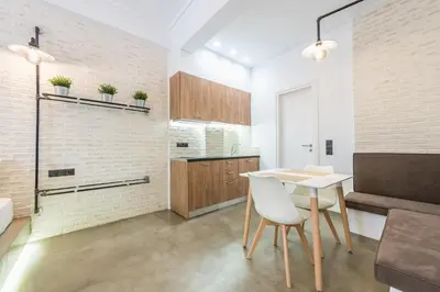 a kitchen with a table and chairs and a brick wall at Stylish 1BR apartment in the heart of Koukaki in Athens