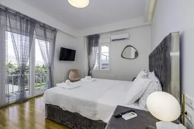 a bedroom with a large bed and a large window at Lush Sapphire apt steps from Acropolis & Plaka! in Athens