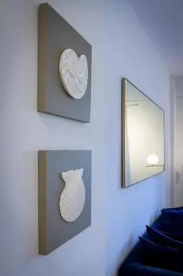 a white vase on a wall next to a mirror at Lush Sapphire apt steps from Acropolis & Plaka! in Athens