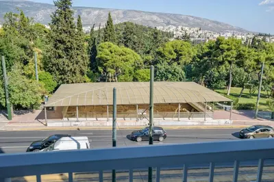 a building with cars parked in a parking lot at Lush Sapphire apt steps from Acropolis & Plaka! in Athens