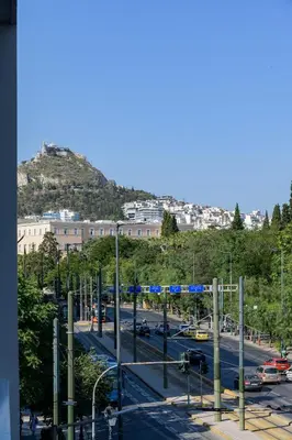 a view of a city street with a hill in the background at Lush Sapphire apt steps from Acropolis & Plaka! in Athens