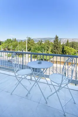 a table and two chairs on a balcony at Lush Sapphire apt steps from Acropolis & Plaka! in Athens