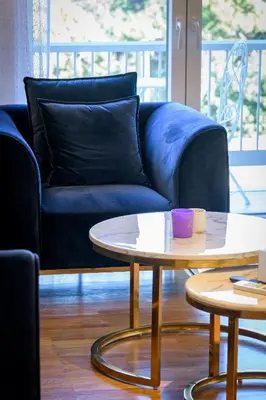 a living room with a blue couch and a table at Lush Sapphire apt steps from Acropolis & Plaka! in Athens