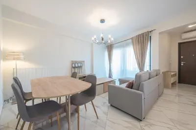 a dining room and living room with a table and chairs at Newly renovated apt in the heart of Kerameikos in Athens