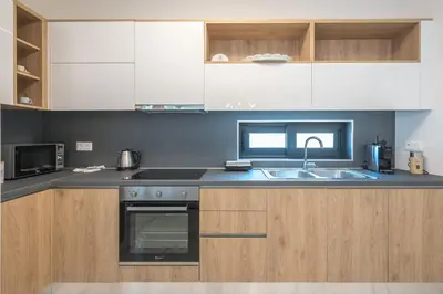 a kitchen with white cabinets and a sink at Newly renovated apt in the heart of Kerameikos in Athens