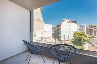two chairs sitting on a balcony with a window at Newly renovated apt in the heart of Kerameikos in Athens