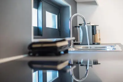 a kitchen counter with a sink and a mirror at Newly renovated apt in the heart of Kerameikos in Athens