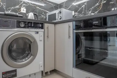 a laundry room with a washer and a microwave at 2 Bedroom condo with dream balcony in Athens