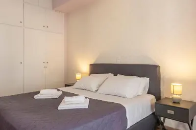 a bedroom with a large bed with two towels on it at 2 Bedroom condo with dream balcony in Athens