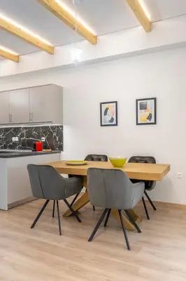 a kitchen and dining room with a wooden table and chairs at 2 Bedroom condo with dream balcony in Athens