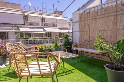 a patio with two chairs and a table and some plants at 2 Bedroom condo with dream balcony in Athens