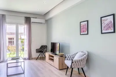 a living room with two chairs and a television at 2 Bedroom condo with dream balcony in Athens
