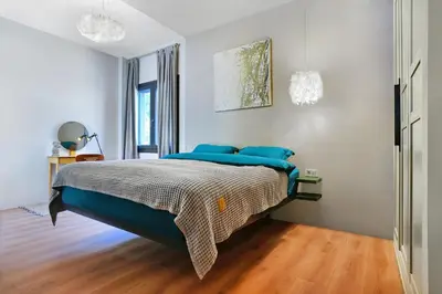 a bedroom with a large bed with blue pillows at P Faliro Riviera Suite in Athens