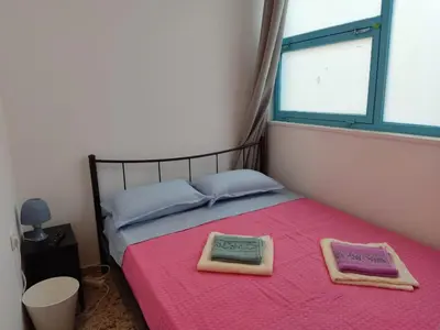 a bedroom with a pink bed with two towels on it at PURE URBAN ACROPOLIS METRO PETRALONA in Athens