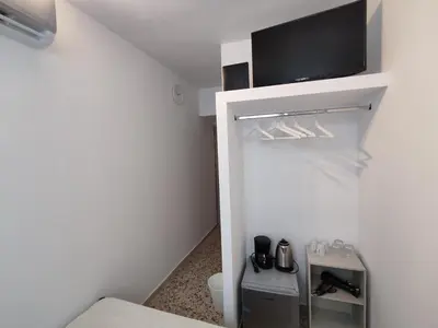 a bathroom with a toilet and a tv on a wall at PURE URBAN ACROPOLIS METRO PETRALONA in Athens