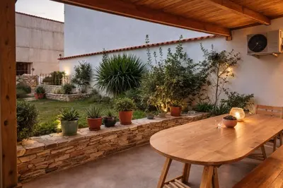 a patio with a wooden table and potted plants at Cozy apartment in Peania (near Airport) in Paianía