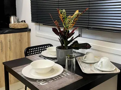 a table with plates and bowls and a plant on it at Our little 1 in Athens