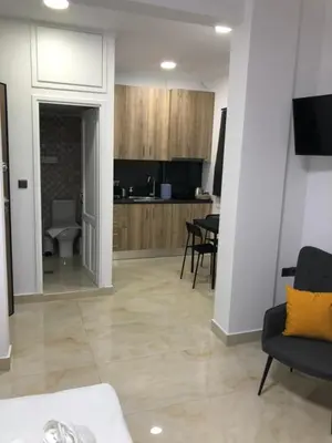 a living room with a couch and a kitchen at Our little 1 in Athens