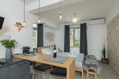 a kitchen and living room with a table and a dining room at Nereid Apartment in Athens