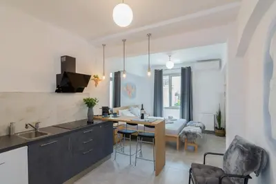 a kitchen and living room with a table and chairs at Nereid Apartment in Athens