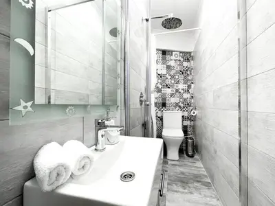a white bathroom with a sink and a toilet at Amazing View 2BR Apartment | Heart of Athens in Athens