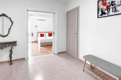 a white room with a bench and a bedroom at Amazing View 2BR Apartment | Heart of Athens in Athens
