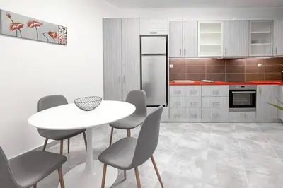 a kitchen with a table and chairs and a refrigerator at Amazing View 2BR Apartment | Heart of Athens in Athens