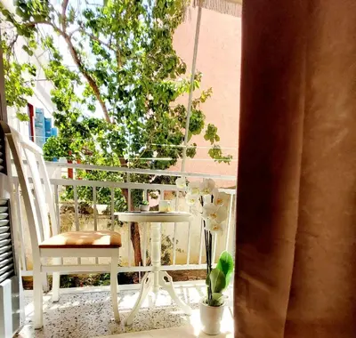 a balcony with a table and a chair and a tree at Lovely equipped apartment in Kallithea Athens in Athens