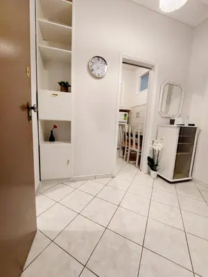 a room with a clock on the wall and a tile floor at Lovely equipped apartment in Kallithea Athens in Athens
