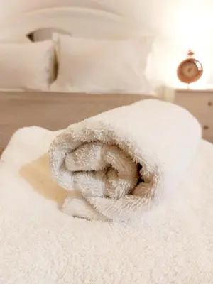 a white towel sitting on top of a bed at Lovely equipped apartment in Kallithea Athens in Athens