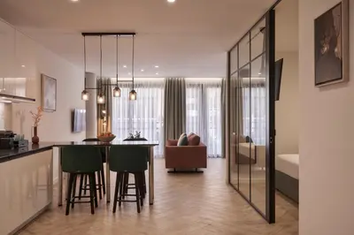 a kitchen and living room with a bar with green chairs at Hestia - Dimitressa 4 in Athens