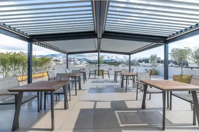 a row of tables and chairs on the roof of a building at Hestia - Dimitressa 4 in Athens