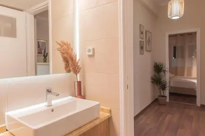 a bathroom with a white sink in a room at Luxury Apartment with Jacuzzi Close to Acropolis - Living Stone Zircon in Athens
