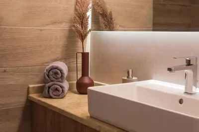 a bathroom with a sink and towels on a counter at Luxury Apartment with Jacuzzi Close to Acropolis - Living Stone Zircon in Athens