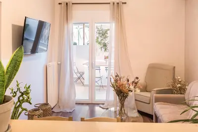 a living room with a couch and a table with flowers at Luxury Apartment with Jacuzzi Close to Acropolis - Living Stone Zircon in Athens