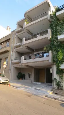 an apartment building with a car parked in front of it at Modern apartment near Acropolis peaceful location. in Athens