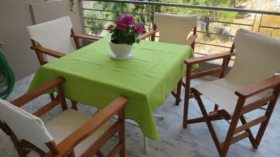 a green table with chairs and a vase of flowers on it at Modern apartment near Acropolis peaceful location. in Athens