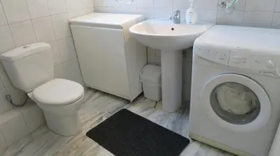 a bathroom with a washing machine and a sink at Modern apartment near Acropolis peaceful location. in Athens