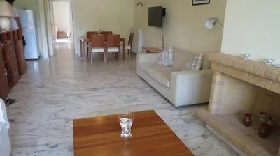a living room with a couch and a vase on a table at Modern apartment near Acropolis peaceful location. in Athens