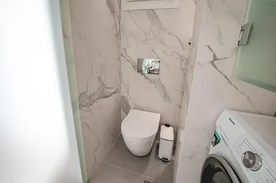 a small bathroom with a toilet and a washing machine at Athena B&B in Athens