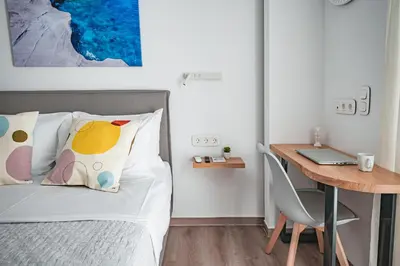 a bedroom with a bed and a desk with a laptop at Athena B&B in Athens