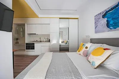 a bedroom with a large bed and a kitchen at Athena B&B in Athens