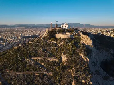 a mountain with a white house on top of it at Athena B&B in Athens