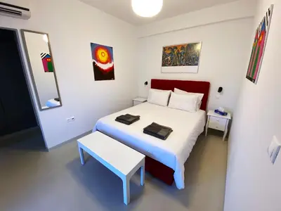 a bedroom with a white bed and a white table at Parthenon and Syntagma square view apartment in Athens