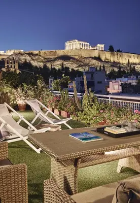 a patio with a table and chairs on the grass at Acropolis Panorama Residence in Athens