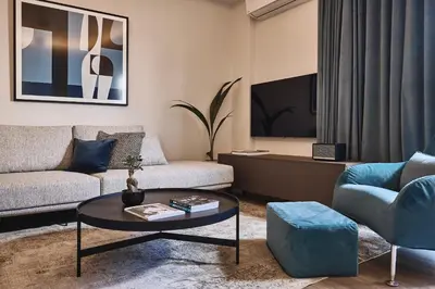 a living room with a couch and a table and a tv at Acropolis Panorama Residence in Athens