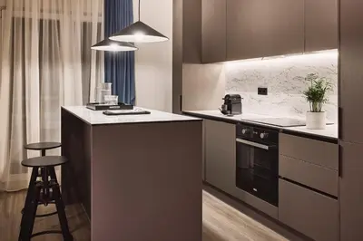a kitchen with a stove and a counter with a stool at Acropolis Panorama Residence in Athens