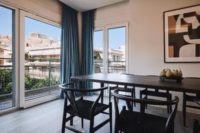 a dining room with a table and chairs and windows at Acropolis Panorama Residence in Athens