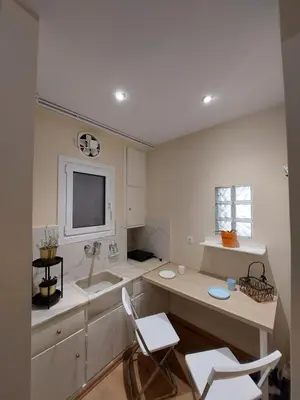 a kitchen with two chairs and a sink and a tv at Kerameikos residence in Athens